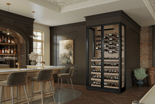 Cave à vin encastrée haut de gamme Cellier Depot dans un intérieur moderne avec table haute et éclairage chaleureux, illustrant l’élégance et le design raffiné des celliers en verre pour la conservation du vin.